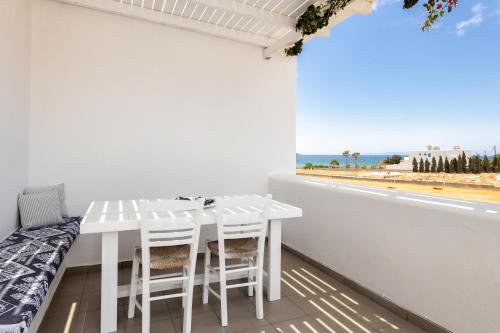 a white dining room with a table and a view of the beach at Golden Beach Hotel in Chrissi Akti