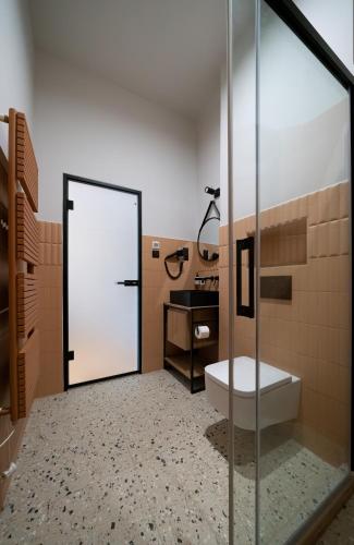 a bathroom with a shower with a toilet and a sink at Nest in Győr
