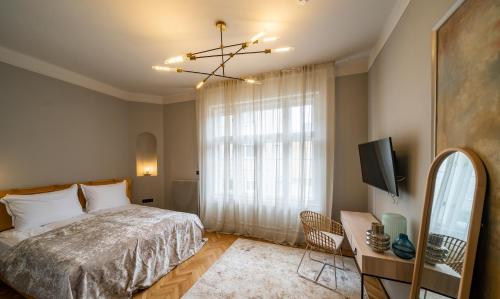 a bedroom with a bed and a tv and a window at Nest in Győr