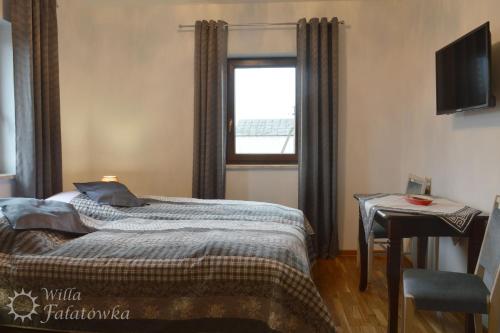 a bedroom with a bed and a window at Willa Fałatówka Mielenko - Mielno Wczasy nad morzem in Mielenko