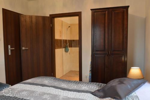 a bedroom with a bed and a closet and a shower at Willa Fałatówka Mielenko - Mielno Wczasy nad morzem in Mielenko