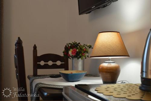 a table with a lamp and a bowl on it at Willa Fałatówka Mielenko - Mielno Wczasy nad morzem in Mielenko