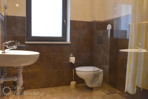 a bathroom with a toilet and a sink at Willa Fałatówka Mielenko - Mielno Wczasy nad morzem in Mielenko