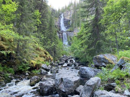 a waterfall in the middle of a river with rocks at Sonfjällsgårdens Wärdshus & Hotell in Hede