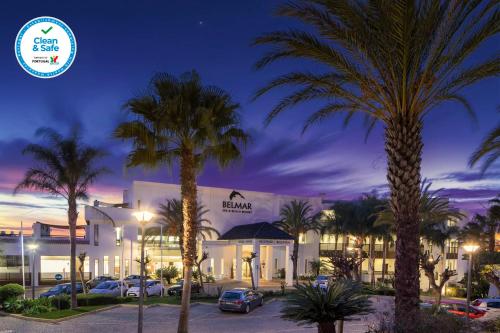 a hotel with palm trees in front of a building at Belmar Spa & Beach Resort in Lagos