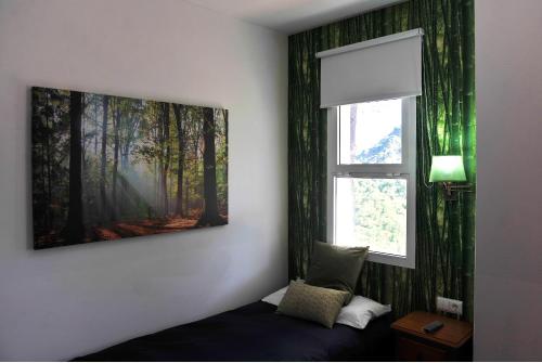 a bedroom with a painting on the wall next to a window at Hotel La Fuentecilla in Algatocín