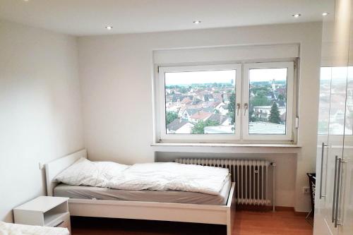 a bedroom with a bed and a large window at Stadtwohnung in Eppelheim bei Heidelberg in Eppelheim