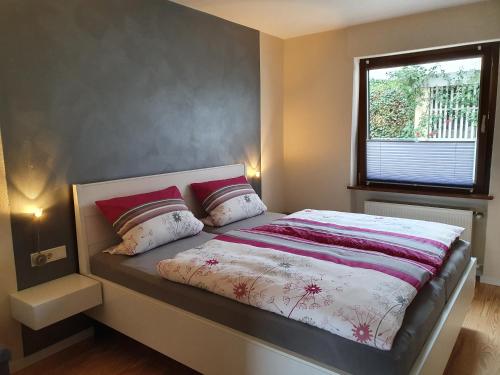 een slaapkamer met een bed met 2 kussens en een raam bij Haus Monika in Zeltingen-Rachtig