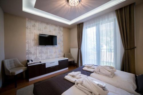 ein Hotelzimmer mit zwei Betten und einem Fernseher in der Unterkunft Hotel DARO in Banská Štiavnica