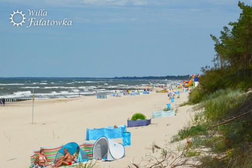a group of people on a beach near the ocean at Willa Fałatówka Mielenko - Mielno Wczasy nad morzem in Mielenko