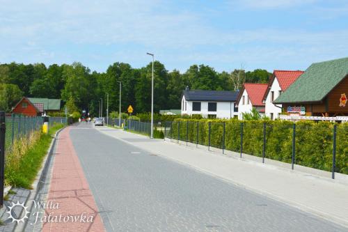 a street with houses and a fence next to a road at Willa Fałatówka Mielenko - Mielno Wczasy nad morzem in Mielenko