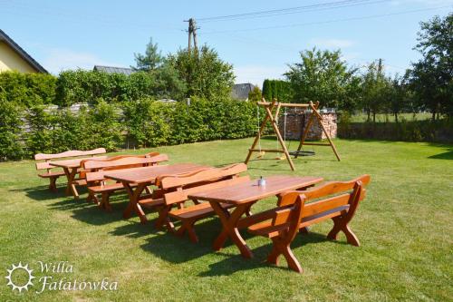 a group of picnic tables and a swing set at Willa Fałatówka Mielenko - Mielno Wczasy nad morzem in Mielenko