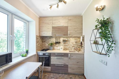 a kitchen with wooden cabinets and a counter top at Comfort 3-Room Apartment with Forest View & 2 Bedrooms in Jūrmala
