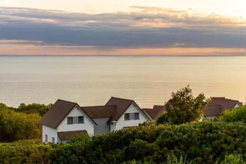 a house on a hill with the ocean in the background at Evancy Equihen-Plage in Équihen-Plage