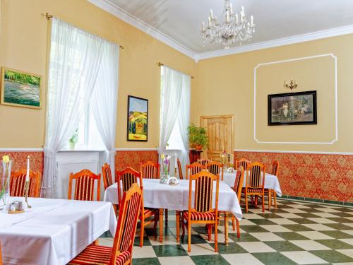 Pałac Pensjonat Ptaszynka في غريفيتسه: غرفة طعام بها طاولات وكراسي وثريا