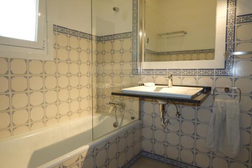 a bathroom with a sink and a tub and a mirror at Horta de Pepinais in Elvas