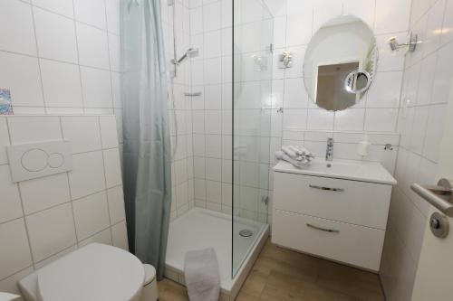 a bathroom with a shower and a toilet and a sink at Hotel-Pension Achtern Diek in Büsum
