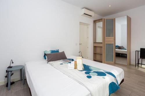 a bedroom with a large white bed with a table at Alma Suites Madrid CH in Madrid