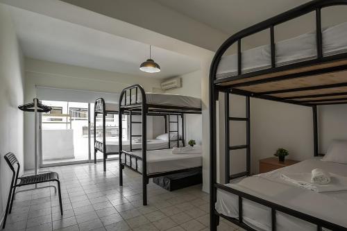 a room with three bunk beds and a bathroom at White Hostel in Limassol
