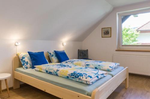 a bedroom with a bed with blue sheets and a window at Apartments Olip in Bled