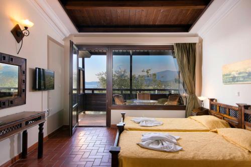 a hotel room with two beds and a balcony at Kallisti Hotel in Potos