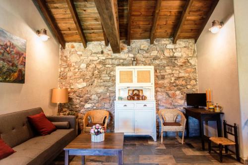 a living room with a couch and a stone wall at Rural Médulas Viviendas de uso turistico 2 y Casas rurales 2 in Las Médulas