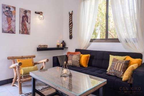 a living room with a black couch and a glass table at Villa Can Kiko in Dahab