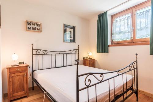 a bedroom with a black bed and a window at Maso Noce in Mezzana