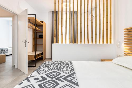 a bedroom with a white bed and a closet at Golden Beach Hotel in Chrissi Akti