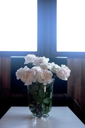 a vase filled with white flowers sitting on a table at Rural Médulas Viviendas de uso turistico 2 y Casas rurales 2 in Las Médulas