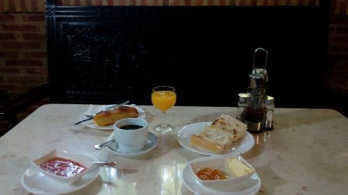 セルセディリャにあるLa Parra de Pepaの食べ物の皿とオレンジジュースのグラスが置かれたテーブル