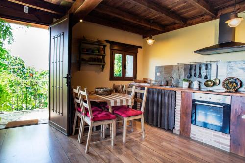 a kitchen with a table and chairs and a stove at Rural Médulas Viviendas de uso turistico 2 y Casas rurales 2 in Las Médulas