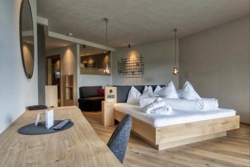 a living room with a bed and a dining table at Hotel Gnollhof in Chiusa