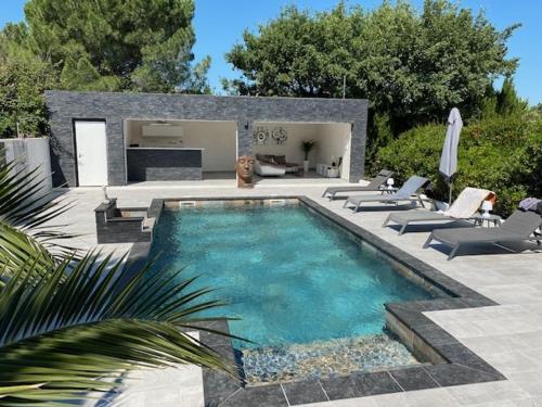 a swimming pool with chairs and a patio with at La désirée'ade in Roquebrune-sur-Argens