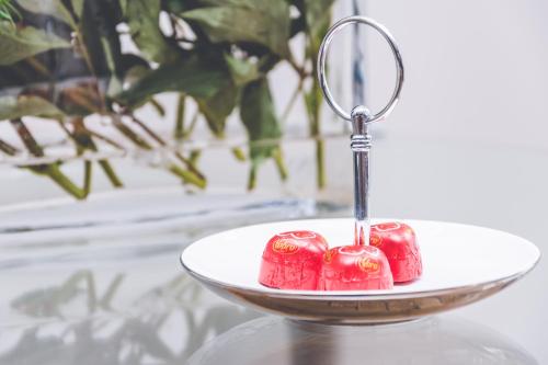 a plate with a red candle holder on a table at Hotel Floryan Old Town in Kraków