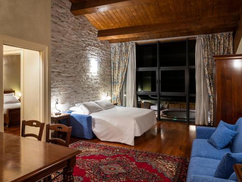 a bedroom with a bed and a couch and a table at Parco Termale di Villa Dei Cedri in Lazise