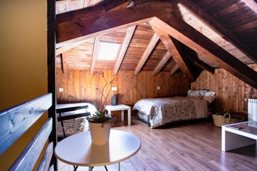 a attic room with a bed and a table at Rural Médulas Viviendas de uso turistico 2 y Casas rurales 2 in Las Médulas