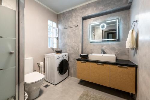 y baño con lavabo y lavadora. en Modern 5BD Apartment in the Heart of Athens, en Atenas