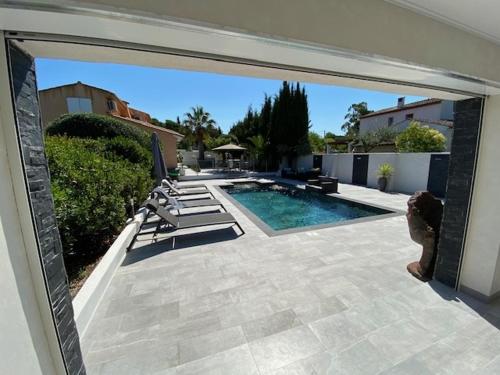 a patio with a pool and chairs and a house at La désirée'ade in Roquebrune-sur-Argens