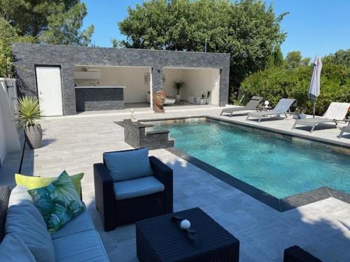 a dog is sitting next to a swimming pool at La désirée'ade in Roquebrune-sur-Argens