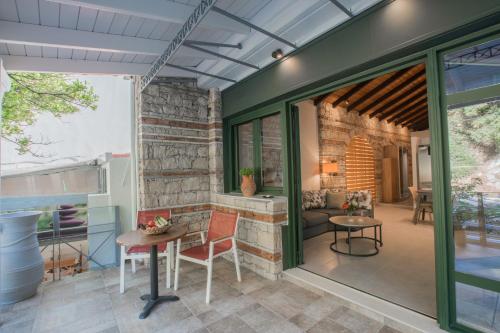 a living room with a brick wall and glass doors at Casa Leone, cosy apartment overlooking the square in Spílion