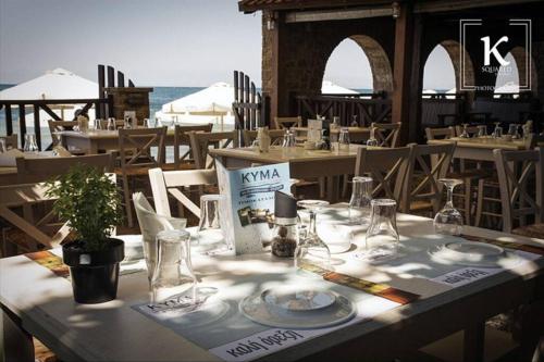 a table with plates and glasses on top of it at Eva Apartment with great view in Epanomi