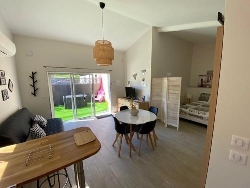 a living room with a table and a bedroom at La désirée'ade in Roquebrune-sur-Argens