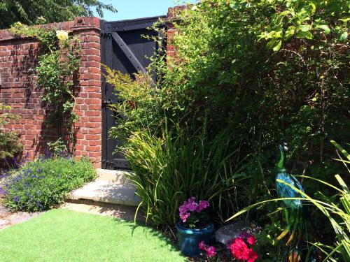 a garden with a statue and flowers in the grass at The Citiroom in Chichester