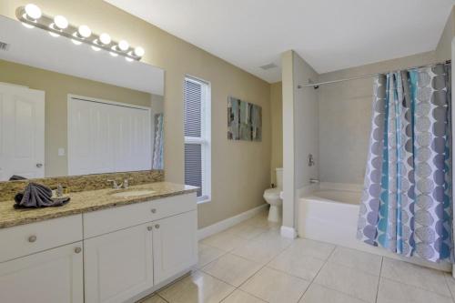 a bathroom with a sink and a tub and a toilet at Villa Valmora in Cape Coral