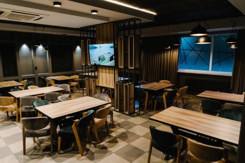 a restaurant with tables and chairs and a flat screen tv at Готельно-рестораний комплекс Silver in Ivano-Frankivsʼk