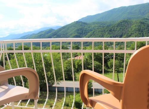 a balcony with chairs and a view of mountains at Guest house Racha in Ambrolauri