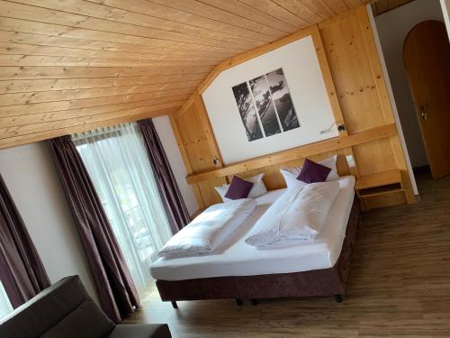 Schlafzimmer mit einem Bett mit Holzdecke in der Unterkunft Hotel Seeluna am Klostersee in Ebersberg