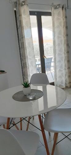 a white table and chairs with a plant on it at Studio Stela 3 in Povljana
