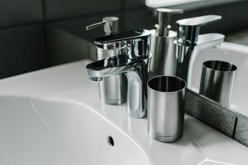 a sink with two faucets and two cups on it at Готельно-рестораний комплекс Silver in Ivano-Frankivsʼk